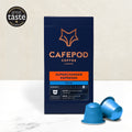 Packaging of CaféPod Coffee's Supercharger Espresso, decaf variety, with two blue coffee pods in front. The packaging is predominantly dark with orange and white text and a graphic of a fox's head.