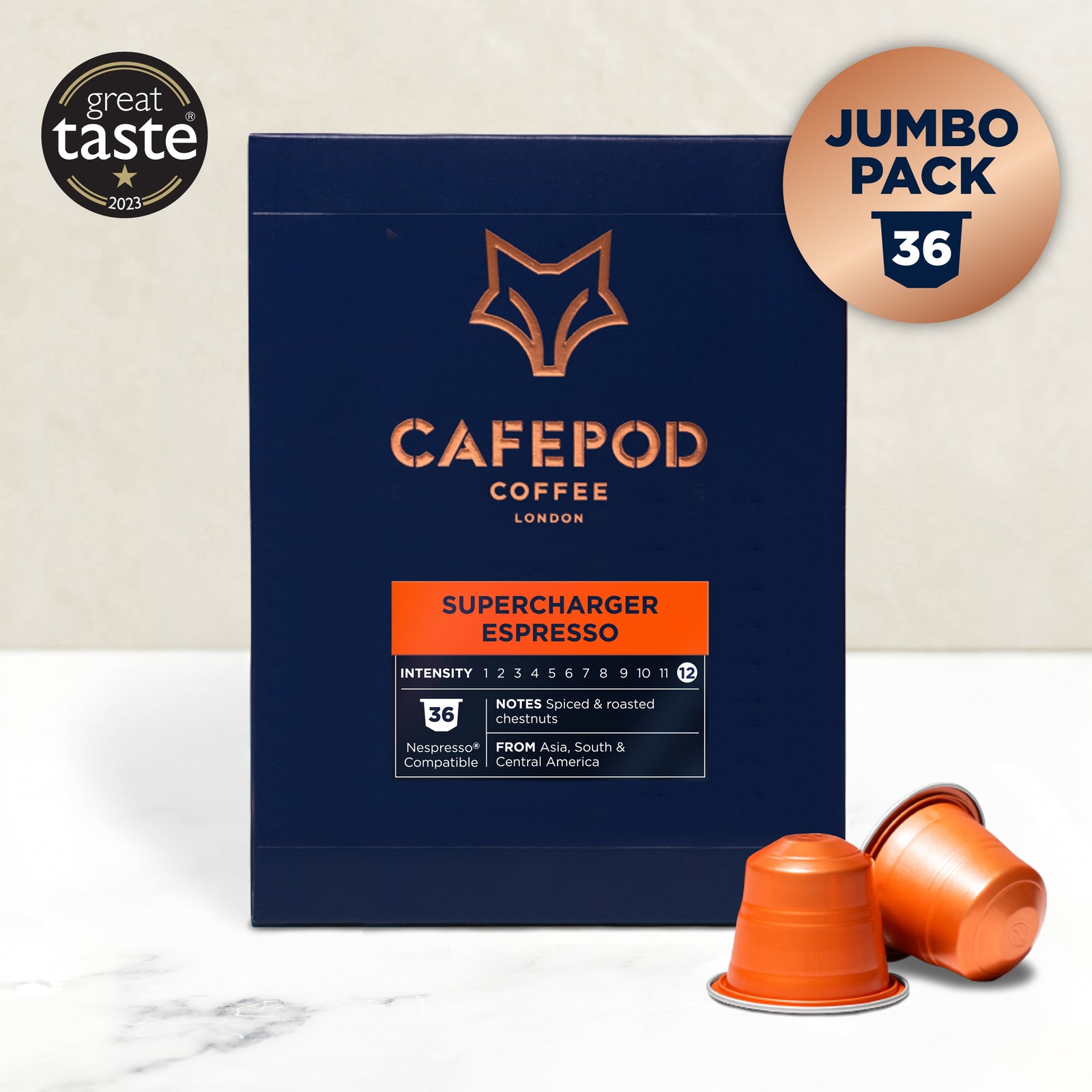 A navy blue box of Cafepod Supercharger Espresso with aGreat Tasteaward badge, indicating a 36 pod pack. Two orange coffee pods are displayed in front.